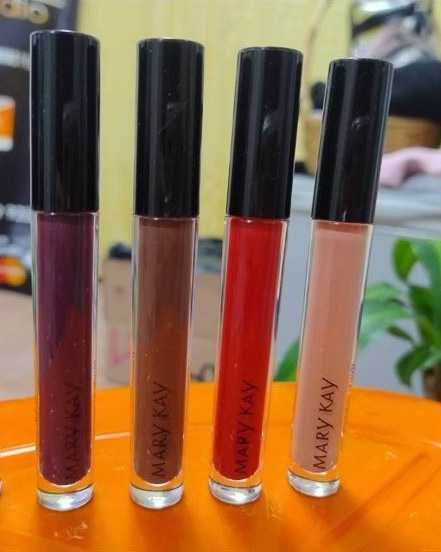 Four lip gloss tubes with black caps in plum, cocoa, red and nude