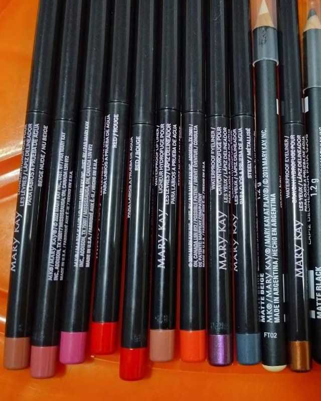 A row of black lip and eye liner pencils with colorful tips